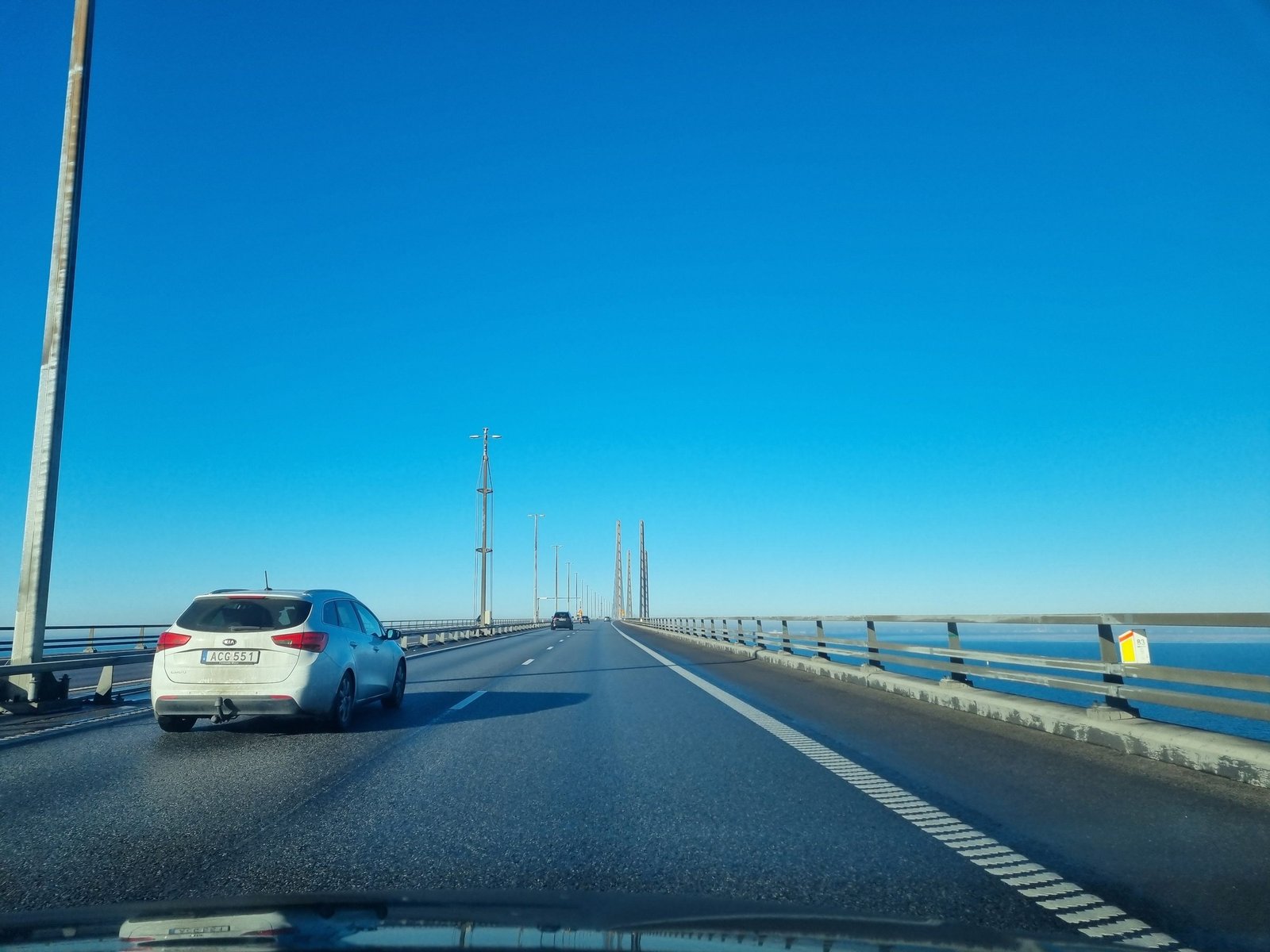 Driving across the Øresund Bridge behind a Swedish car, with the pylons in the distance