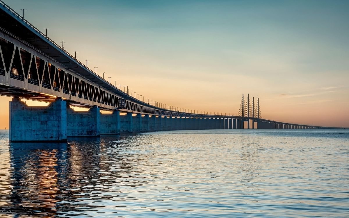 The Øresund Bridge at sunset seen from the water, with the railway deck below the road